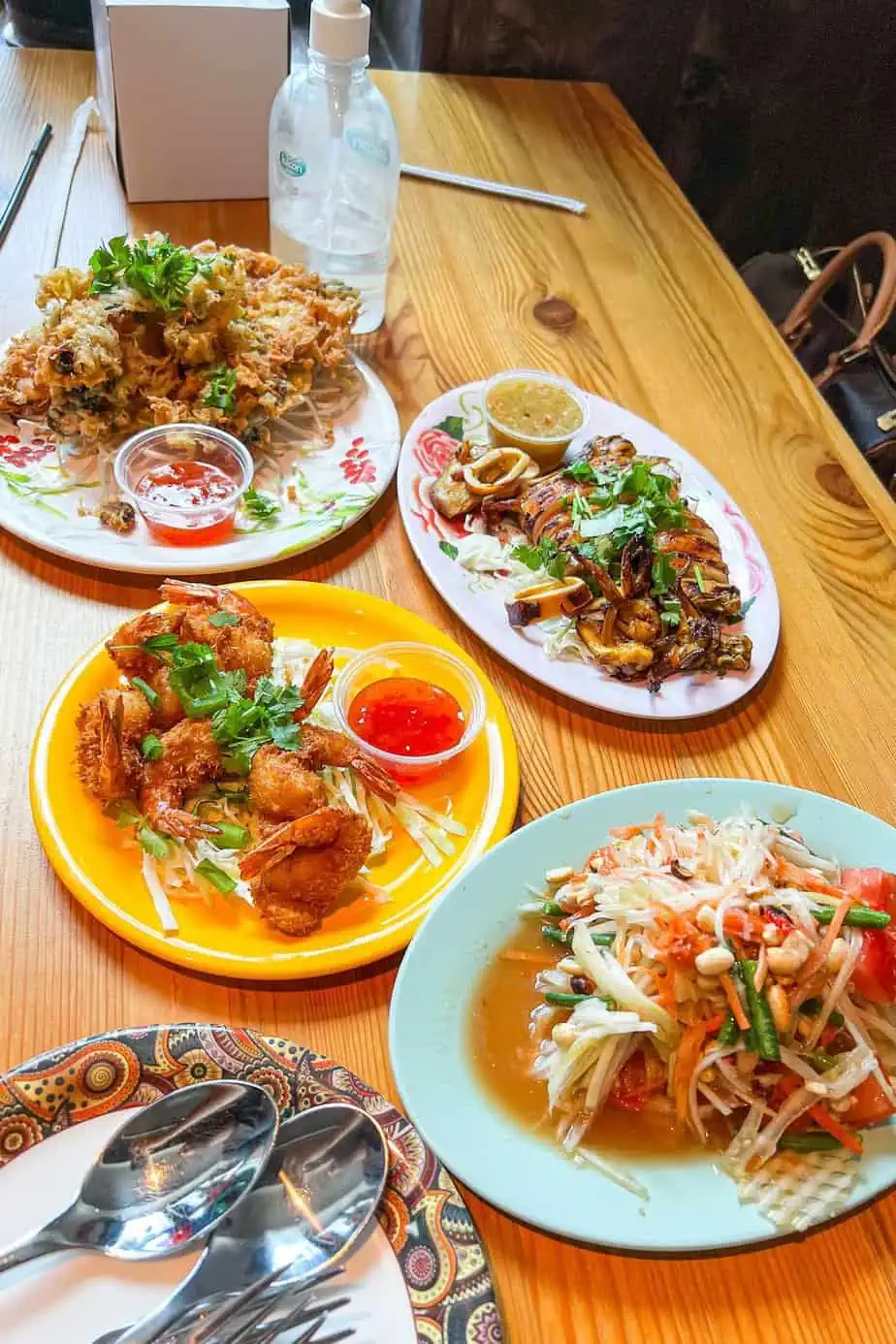 Cafe Isan JLT's collection of Thai dishes over lunch including a mussel omelette, charred baby squid, coconut ship and a papaya salad.