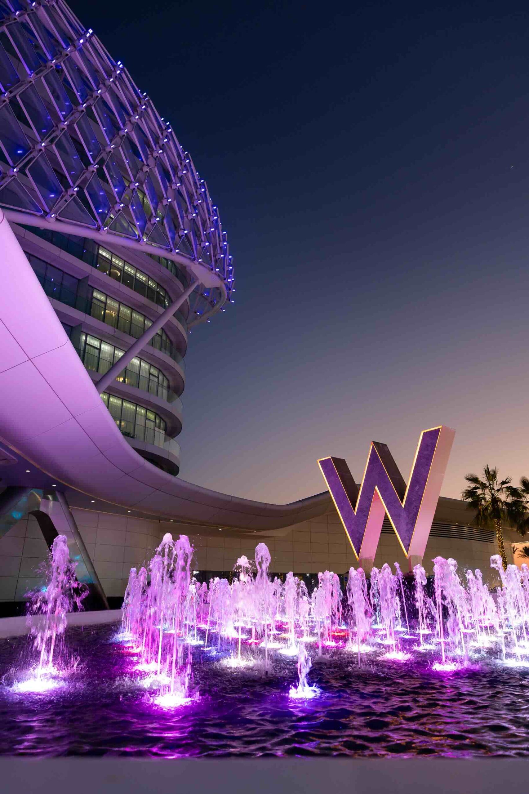 W Abu Dhabi - Yas Island's fountains at the entrance of the hotel with the W logo tinted in purple.