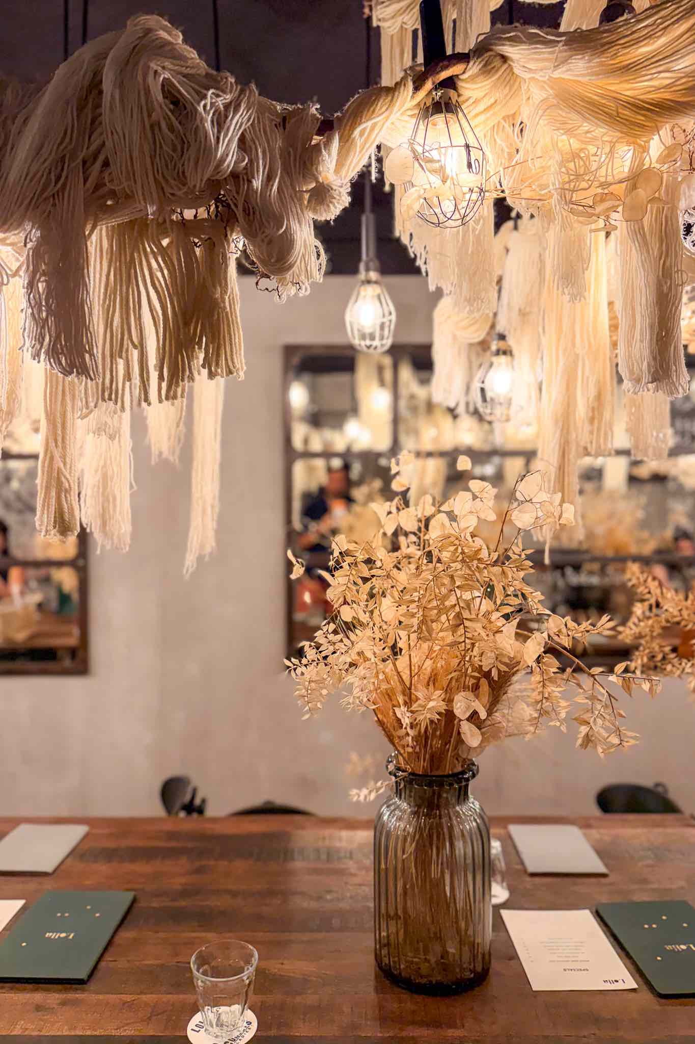 Lolla's downstair communal table with ropes, vintage style glassware and mirrored walls.