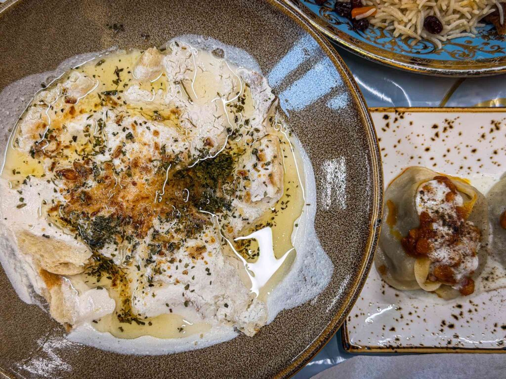 Afghan qurooti, torn bread soaked in salted hung yoghurt paste topped with fried garlic, oil and dried mint