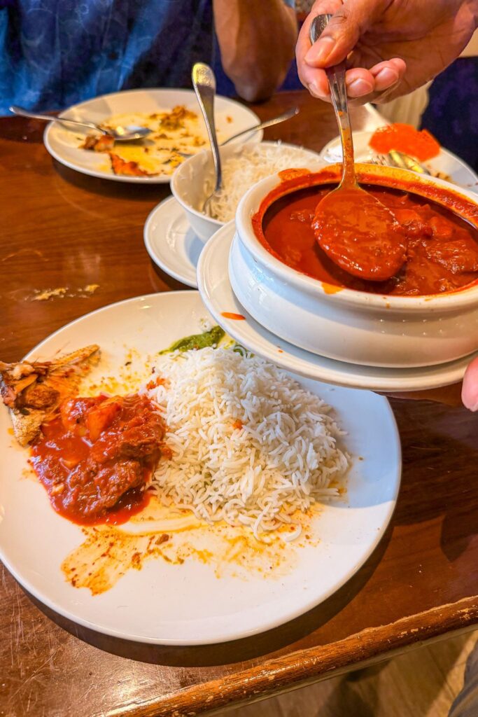 Bowl of red beef vindaloo being served beside steamed rice at Eric’s Restaurant in Dubai