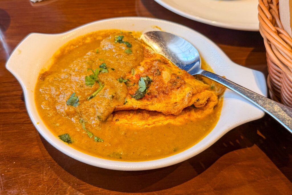 Goan ros omelette covered with curry gravy at Eric’s Restaurant in Dubai