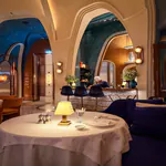 Interior of Rialto showing a white-clothed dining table, high arched openings, blue walls and a chef working behind the counter.
