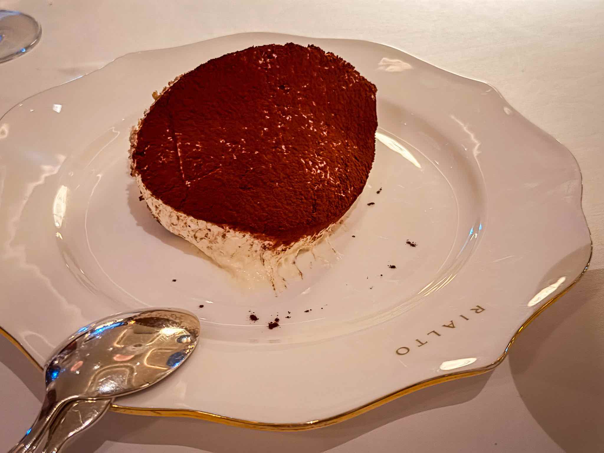 Large square portion of tiramisu dusted with cocoa on a white Rialto plate.