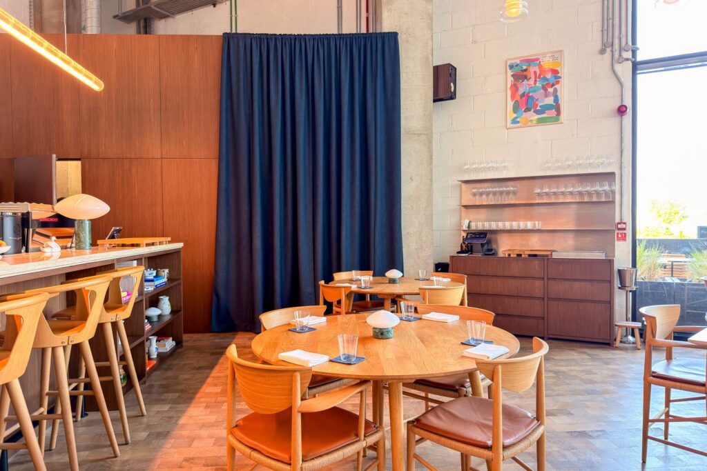 Interior of Blue restaurant, Saadiyat, with a cobalt curtain, oak counter stools, Danish modern chairs and a glassware station
