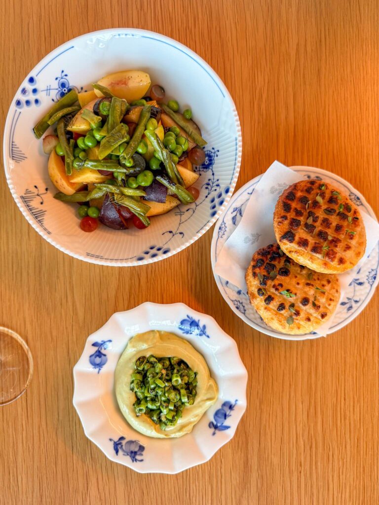 Stone fruit and legume salad, pea hummus with seared beans, and grilled potato flatbread on Royal Copenhagen plates at Blue, Abu Dhabi