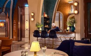 Interior of Rialto showing a white-clothed dining table, high arched openings, blue walls and a chef working behind the counter.